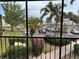 A screened balcony overlooking a parking area with many palm trees and landscaping at 618 Bird Bay S Dr # 212, Venice, FL 34285