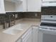 The kitchen features white cabinets and appliances, with a large sink and mosaic backsplash at 618 Bird Bay S Dr # 212, Venice, FL 34285