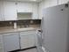 The kitchen features white cabinets and appliances, with a large sink and mosaic backsplash at 618 Bird Bay S Dr # 212, Venice, FL 34285
