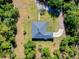 Aerial shot of a home nestled among trees, surrounded by lush greenery and a long driveway at 6293 Taneytown St, North Port, FL 34291