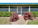 Close-up of screened porch with lush hedges, colorful plants, and a brick pathway at 6293 Taneytown St, North Port, FL 34291