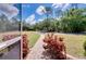 View from screened porch to a winding driveway, mature trees, and neatly maintained lawn at 6293 Taneytown St, North Port, FL 34291