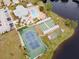 Aerial view of the community amenities including the pool, clubhouse, and tennis courts at 657 Foxwood Blvd, Englewood, FL 34223