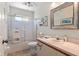 Bright bathroom features a glass shower, a neutral vanity, and an ornate framed mirror at 657 Foxwood Blvd, Englewood, FL 34223