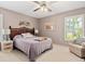 Comfortable bedroom with a ceiling fan and natural light from a large window at 657 Foxwood Blvd, Englewood, FL 34223