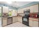 Well-lit kitchen with stainless steel appliances and ample counter space at 657 Foxwood Blvd, Englewood, FL 34223