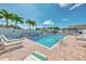 Inviting community pool area with lounge chairs and palm trees at 710 Ironwood Dr # 165, Venice, FL 34292