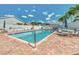 Beautiful community pool with chairs, tables, and an umbrella at 710 Ironwood Dr # 165, Venice, FL 34292