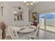 Charming dining area with a round table, white chairs, and sliding glass doors to the patio at 710 Ironwood Dr # 165, Venice, FL 34292