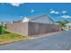 Exterior of the home featuring a brown privacy fence, landscaping, and a paved street at 710 Ironwood Dr # 165, Venice, FL 34292
