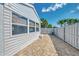 Exterior backyard featuring a brick-paved area with a white fence and view of the home's siding at 710 Ironwood Dr # 165, Venice, FL 34292