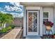 Charming entryway with decorative storm door, brick walkway, and lush landscaping at 710 Ironwood Dr # 165, Venice, FL 34292