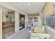 Bright sunroom featuring tile floors, a glass table with seating, and sliding glass doors to the living area at 710 Ironwood Dr # 165, Venice, FL 34292