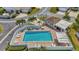 Aerial view of a bright blue community swimming pool with plenty of lounge chairs and palm trees at 710 Ironwood Dr # 165, Venice, FL 34292