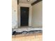 A black front door, brick planter, and white chair at 744 Avenida Estancia # 142, Venice, FL 34292
