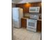 A kitchen with white appliances and dark wood cabinets at 744 Avenida Estancia # 142, Venice, FL 34292