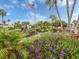 Community park with American flag, flowering plants, bench, and mature trees at 758 Village Cir # 106, Venice, FL 34292