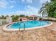 Community pool with brick paver deck, seating, and outdoor kitchen at 758 Village Cir # 106, Venice, FL 34292
