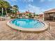 Community pool and surrounding area with seating, landscaping, and community building at 758 Village Cir # 106, Venice, FL 34292