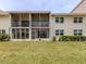 Back view of building exterior with patios, lawn and landscaping at 758 Village Cir # 106, Venice, FL 34292