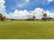 Scenic view of the meticulously maintained green golf course under a beautiful blue sky with white clouds at 758 Village Cir # 106, Venice, FL 34292