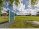Golf course featuring a tee box surrounded by lush green grass and palm trees under a bright blue sky at 758 Village Cir # 106, Venice, FL 34292