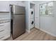 Kitchen area featuring stainless steel refrigerator and stacked washer/dryer at 758 Village Cir # 106, Venice, FL 34292