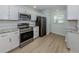 Modern kitchen featuring stainless steel appliances, white cabinets, and granite counters at 758 Village Cir # 106, Venice, FL 34292