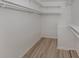 Clean and organized walk-in closet with built-in shelving and modern wood floor at 758 Village Cir # 106, Venice, FL 34292