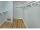 Spacious walk-in closet offering ample storage with wood floor and shelves at 758 Village Cir # 106, Venice, FL 34292