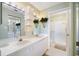 Bright bathroom with dual sinks, decorative plants, ample lighting, and a glass enclosed shower at 821 Waterside Dr # 205, Venice, FL 34285