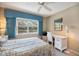 Bedroom with a large window, wicker furniture, a work space, and bright blue valences at 821 Waterside Dr # 205, Venice, FL 34285