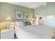 Comfortable bedroom featuring a king bed, decorative lamps, and tranquil, soft green colored walls at 821 Waterside Dr # 205, Venice, FL 34285