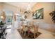 Open dining area with modern chandelier, glass table, and adjacent kitchen access at 821 Waterside Dr # 205, Venice, FL 34285