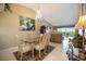 Open-concept dining room with glass table and chandelier lighting next to the cozy living space at 821 Waterside Dr # 205, Venice, FL 34285