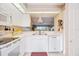 Modern, all-white kitchen with stainless steel appliances and view to dinette at 821 Waterside Dr # 205, Venice, FL 34285