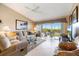 Comfortable living room featuring neutral colors, tile flooring, and sliding glass doors to the outdoor balcony at 821 Waterside Dr # 205, Venice, FL 34285