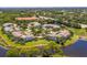 An aerial view of lakefront condos with private garages, meticulously maintained lawns and lush landscaping at 904 Addington Ct # 204, Venice, FL 34293