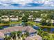 Beautiful aerial view of lakeside condominiums with lush tropical landscaping and blue skies at 904 Addington Ct # 204, Venice, FL 34293
