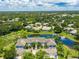 Scenic aerial view of condos with private garages, surrounded by water, lush landscaping and manicured lawns at 904 Addington Ct # 204, Venice, FL 34293