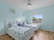 Bright bedroom with two twin beds, ceiling fan, and light blue walls decorated with nautical decor at 904 Addington Ct # 204, Venice, FL 34293