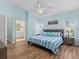 Coastal bedroom features a blue and white color scheme, a ceiling fan, and an ensuite bathroom at 904 Addington Ct # 204, Venice, FL 34293