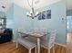 Bright dining area featuring modern light fixture, seating, and coastal art, creating an inviting space at 904 Addington Ct # 204, Venice, FL 34293