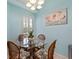 Charming dining area with a glass table, four rattan chairs, and a floral painting at 904 Addington Ct # 204, Venice, FL 34293