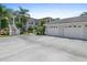 Wide shot of condo exterior with dual car garages, lush greenery, and easy stair access to units at 904 Addington Ct # 204, Venice, FL 34293