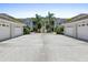 Condominium exterior featuring attached garages, palm trees, and manicured lawns under a clear sky at 904 Addington Ct # 204, Venice, FL 34293