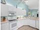 Bright kitchen featuring white cabinets, oven, microwave, and a tiled floor at 904 Addington Ct # 204, Venice, FL 34293