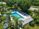 An aerial view of a community pool with lounge chairs and lush tropical landscaping at 904 Addington Ct # 204, Venice, FL 34293