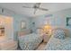 Cozy bedroom with twin beds, beach-themed decor, and a view into the kitchen space at 950 Tarpon Center Dr # 504, Venice, FL 34285