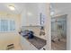 Bright kitchenette featuring white cabinetry, granite counters, and modern appliances, adjacent to the bedroom at 950 Tarpon Center Dr # 504, Venice, FL 34285